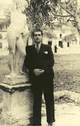 Lezama c. 1935, recostado a una estatua de Apolo en los jardines del Anfiteatro de La Habana.