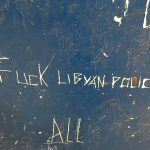 Fuck Libyan police written on a blue wall-Credit-The Outlaw Ocean Project