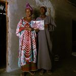 May 26, 2021 – Aliou’s mother and father, Aminata Balde and Samba Cande, at their family home in rural Guinea Bissau with a photo of themselves with Aliou and his brother when they were younger 4