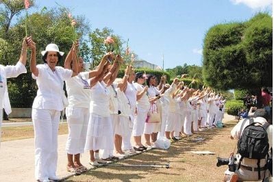 Damas de Blanco se toman de las manos y elevan sus gladiolos en La Habana.