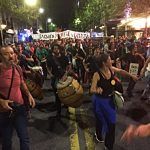 Women dance in blue skirts at protest