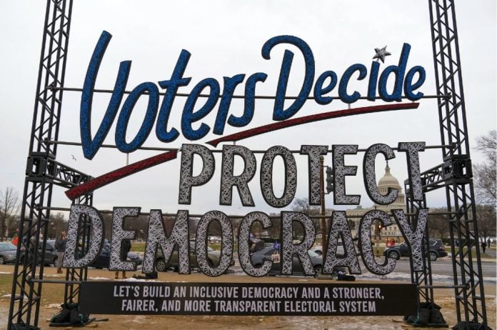 «Deciden los votantes. Protejamos la democracia». Cartel en las afueras del Capitolio, Washington D.C., 6 de enero de 2022, en el primer aniversario del ataque contra ese edificio.
