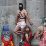 Alberto enmascarado en el centro durante performance en las calles de Quito, como parte de los talleres del espectáculo Monstra Cabaret