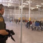 Guardia fronterizo estadounidense custodia a migrantes