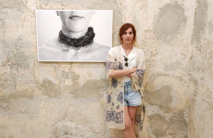 Laura Capote Mercadal junto a una imagen de su expo 