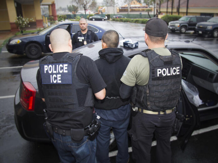 Agentes de ICE cargan con un migrant / Foto: AP