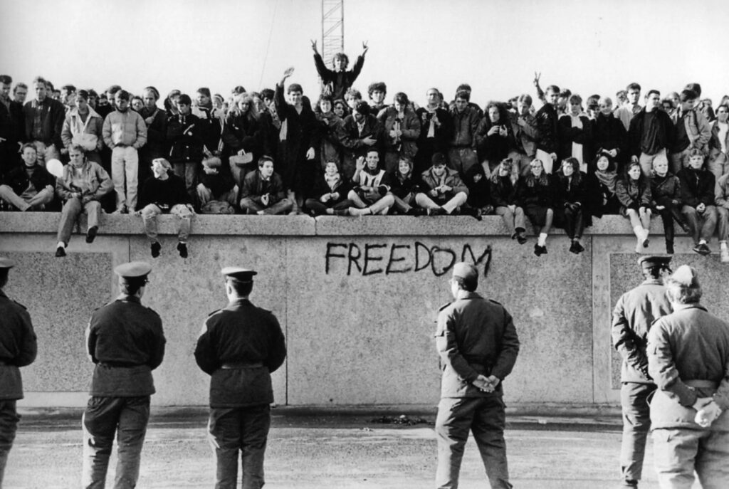 Estudiantes de Alemania oriental sentados sobre el muro de Berlín en noviembre de 1989 / foto: Universidad de Minnesota
