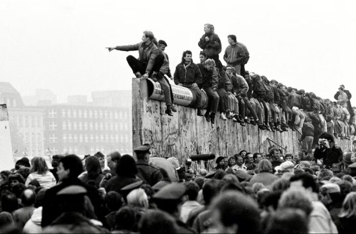 Estudiantes de Alemania oriental sentados sobre el muro de Berlín en noviembre de 1989 / Foto: Universidad de Minnesota